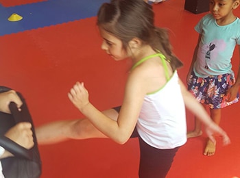 little girl kicking pad